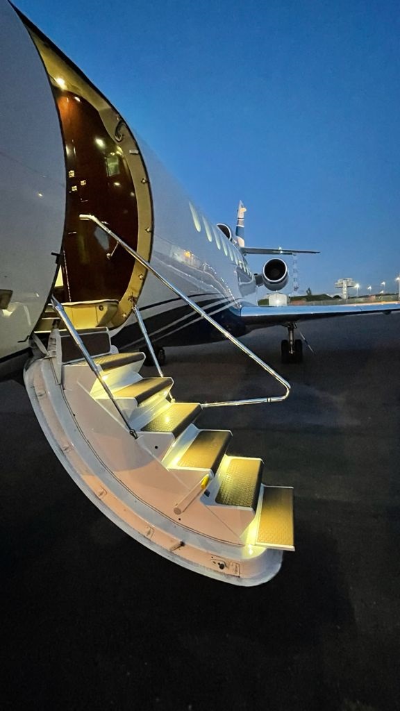 Lit stairway to the aircraft cabin at dusk